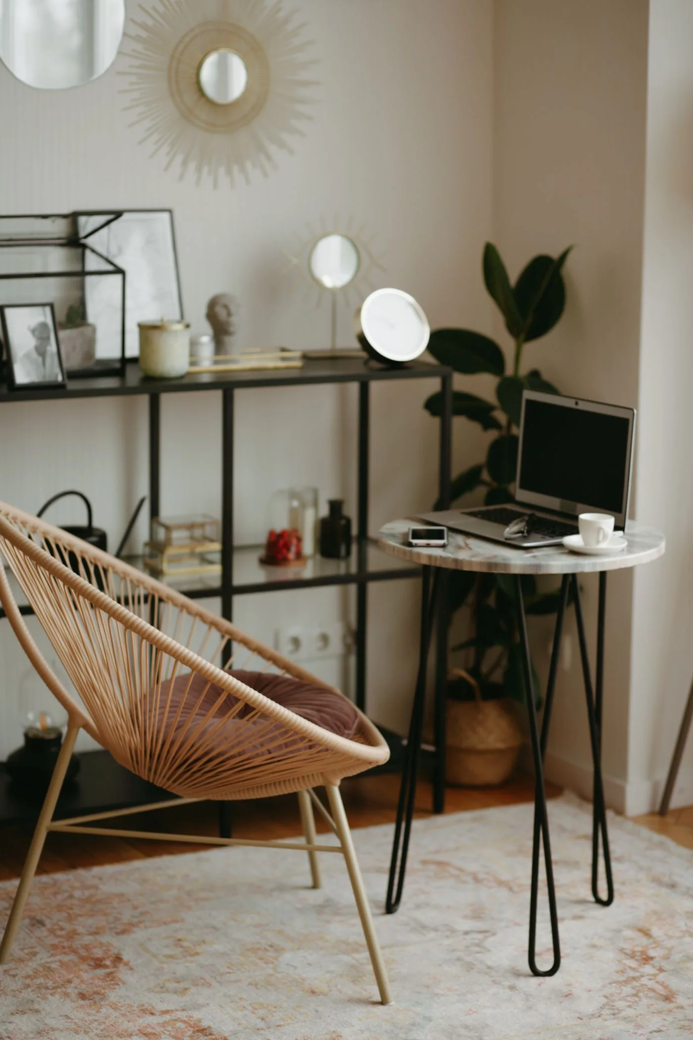 A modern home office with a laptop, stylish chair, shelves, and decor for a cozy work-from-home setup.