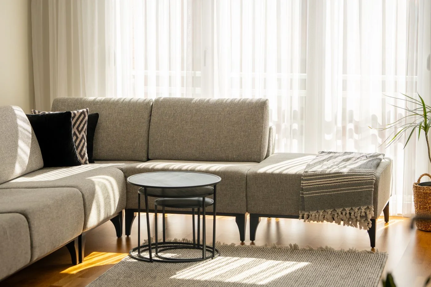 Bright minimalist living room interior with sectional sofa and natural light in Kosovo.