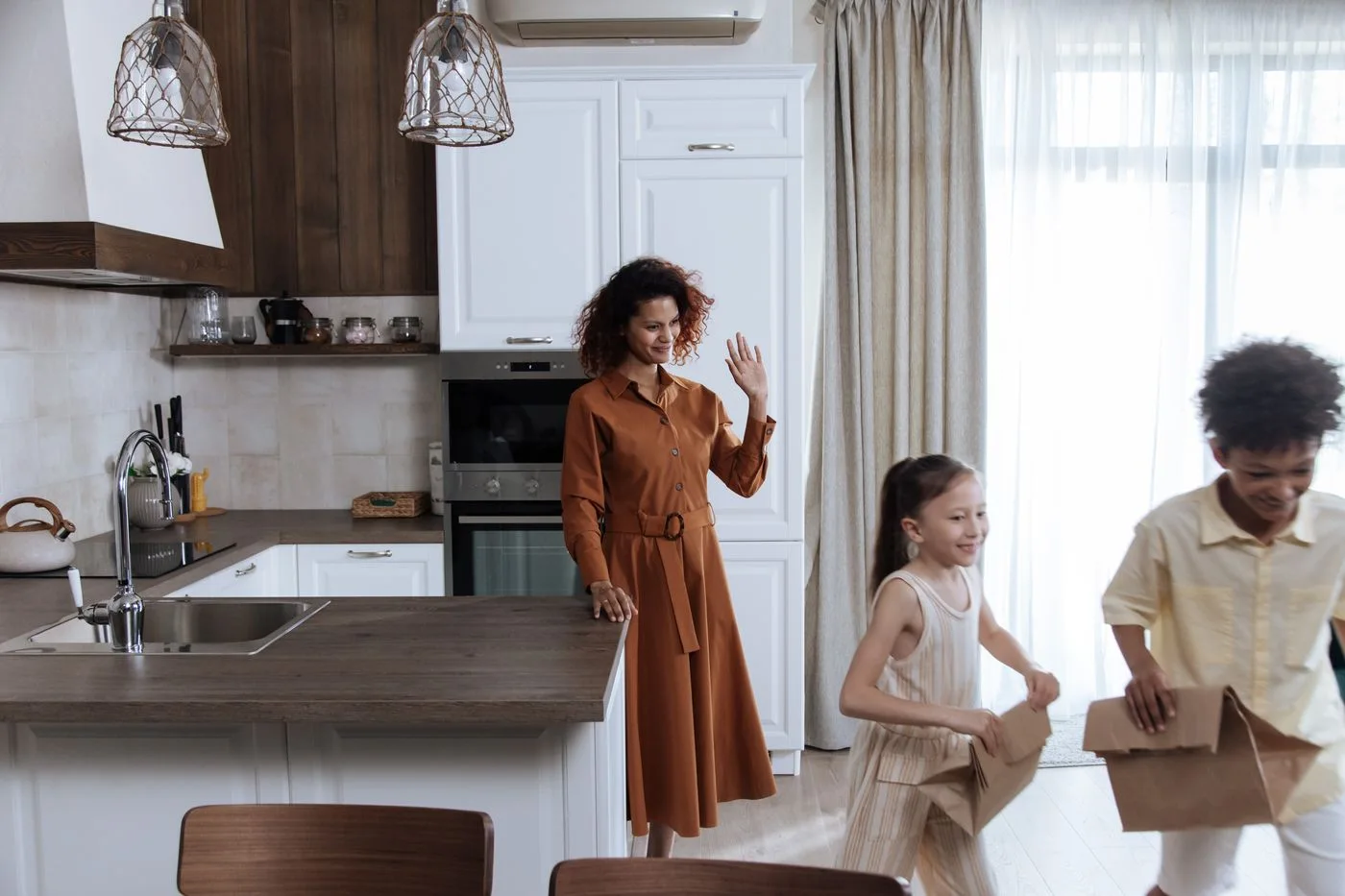 Three people standing together in a home kitchen