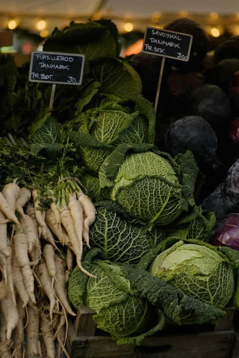 Cabbages and pale root vegetables displayed at a market