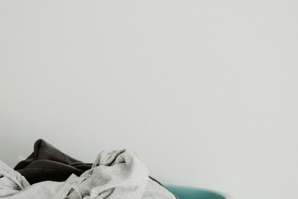Pale and dark folded textiles resting on a bed