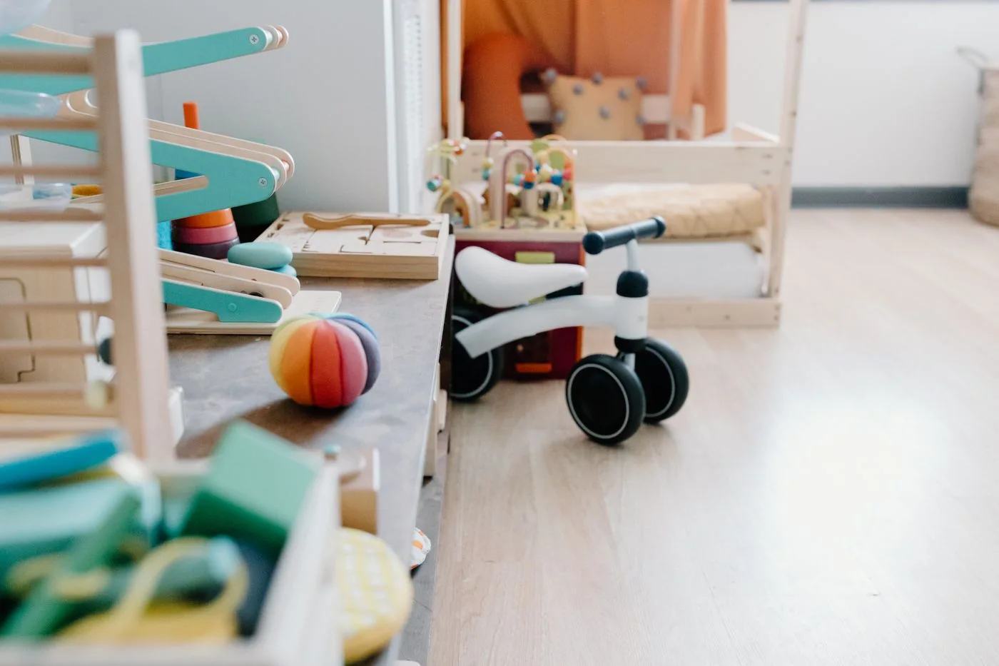 Wooden toys, a small ball and a balance bike in a playroom