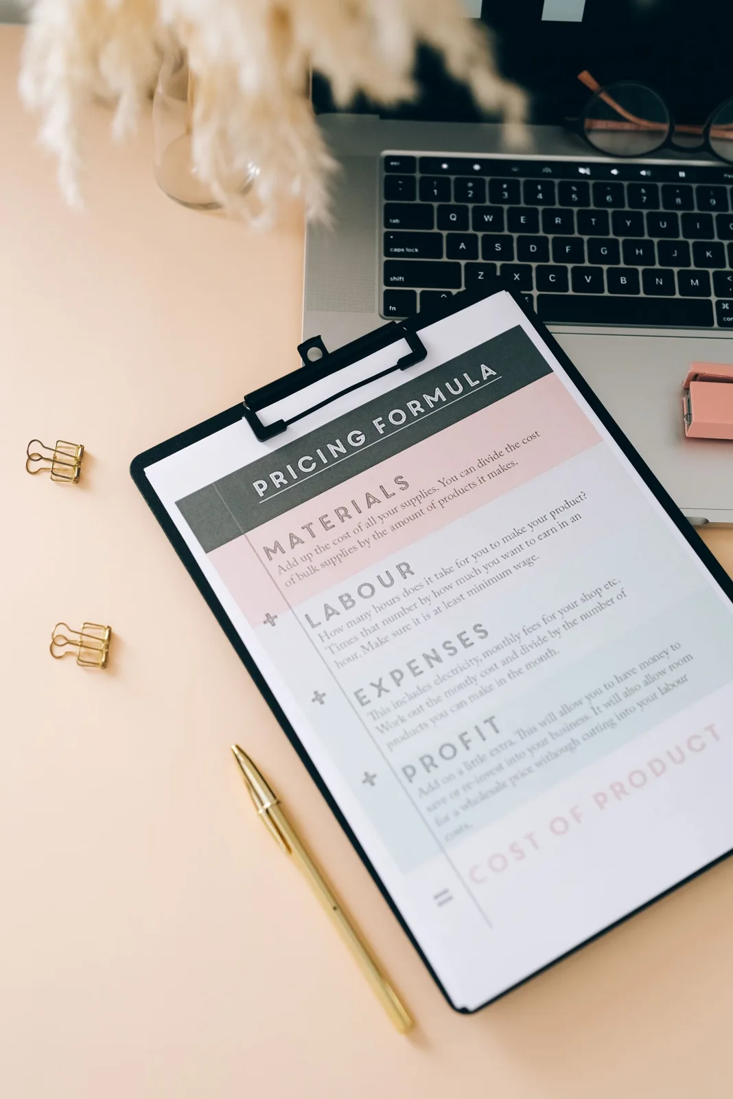 A clipboard with a printed pricing form beside stationery
