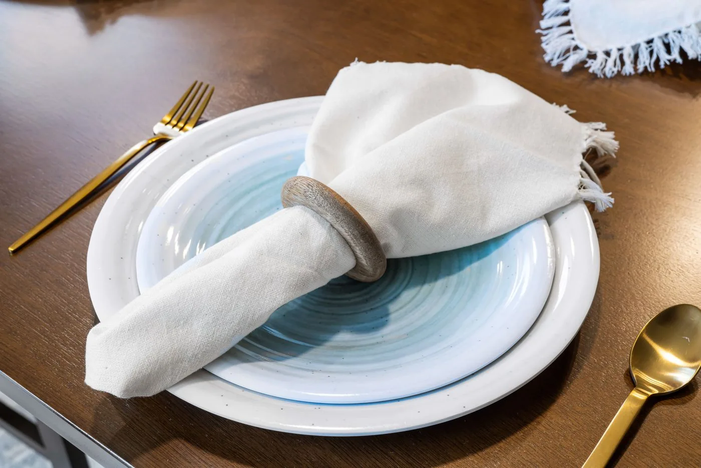White plates with a linen napkin and gold cutlery on a dining table