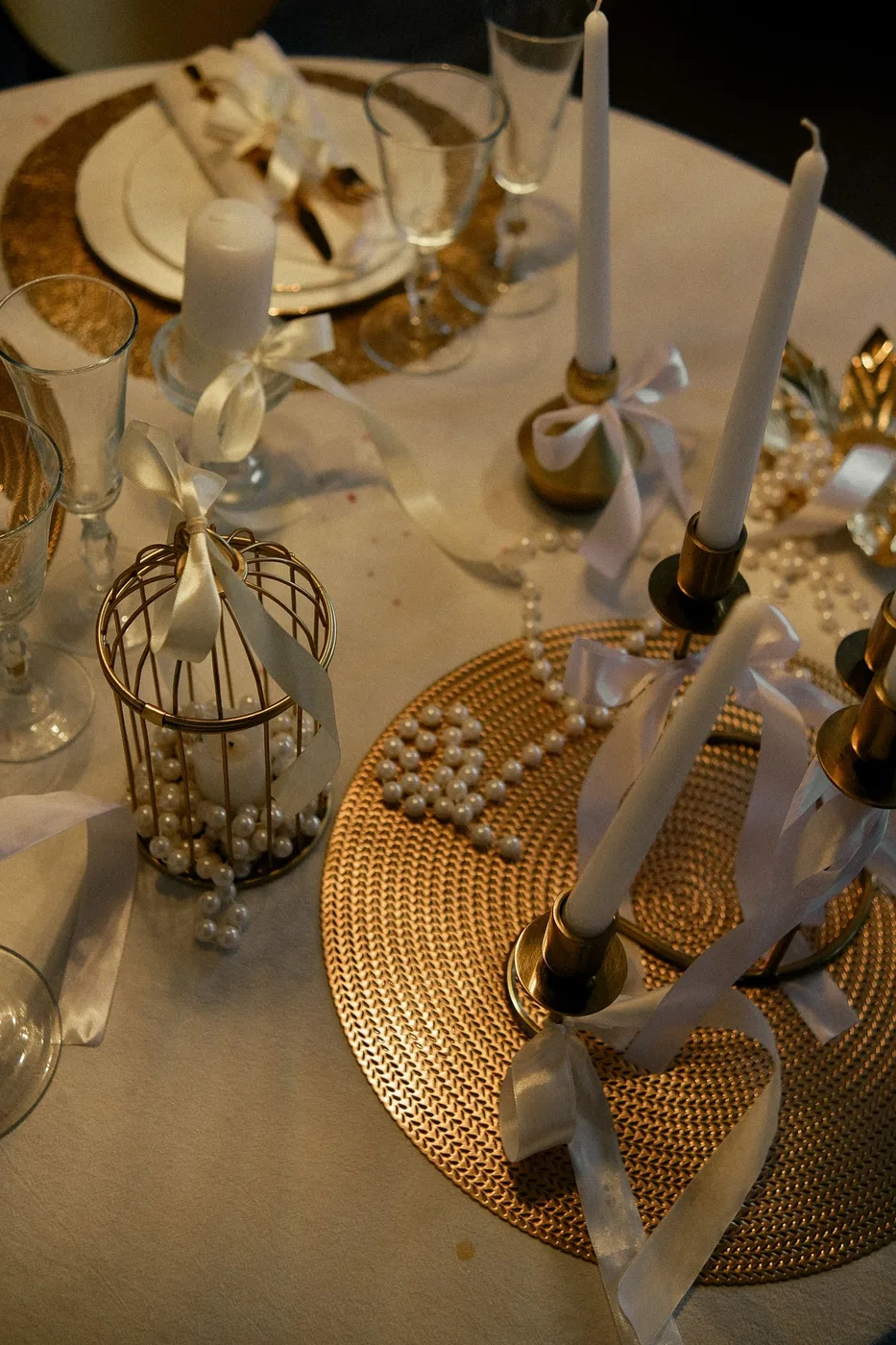 Candles, ribbon and glassware arranged on a table